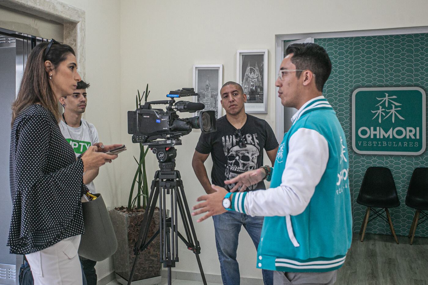 Marco Ohmori dá entrevista à repórter da Globo na recepção da escola